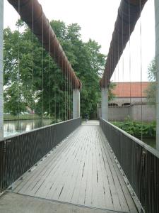 a bridge over a river with a person walking on it at B&B Waterside in Bruges