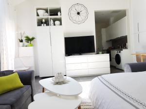 a white bedroom with a bed and a tv at Super Studio cosy proche de CDG - Jeux Olympique 2024 in Le Thillay