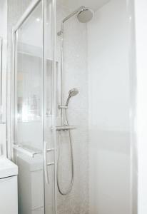 La salle de bains est pourvue d'une douche avec une porte en verre. dans l'établissement Super Studio cosy proche de CDG - Jeux Olympique 2024, à Le Thillay