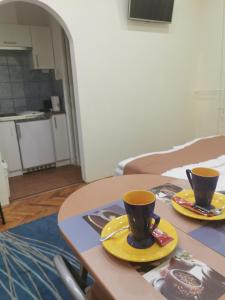 two coffee cups on a table in a room at Baross-hat 4 in Szolnok