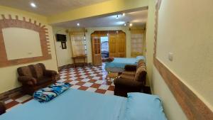 een slaapkamer met 2 bedden en een woonkamer bij Hotel Don Chema in San Pedro La Laguna