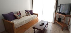 a living room with a couch and a tv at Apartamento Micro Centro para 4 con cochera in Bahía Blanca +3 photos