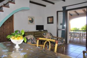 a living room with a table and chairs and a desk at Villetta Nanny II in Santa Teresa Gallura