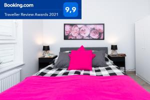 een slaapkamer met een roze bed met roze kussens bij Apartment Antonio in Gdańsk