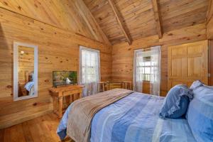 1 dormitorio con 1 cama en una cabaña de madera en Beautiful View! Log cabin,Fireplace,Hot Tub,Arcade,Pool,Fishing en Sevierville