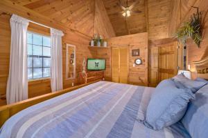 1 dormitorio con 1 cama grande y TV en Beautiful View! Log cabin,Fireplace,Hot Tub,Arcade,Pool,Fishing en Sevierville