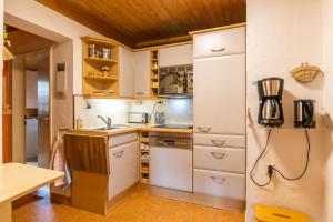 アインルールにあるFerienwohnung-Mediterranのキッチン(白いキャビネット、冷蔵庫付)