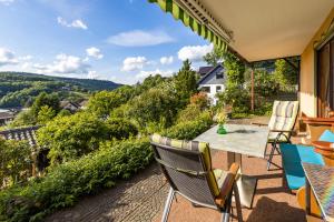 eine Terrasse mit einem Tisch und Stühlen auf dem Balkon in der Unterkunft Ferienwohnung-Mediterran in Einruhr