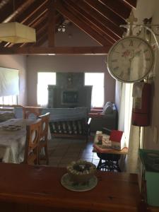 a living room with a large clock on the wall at Die Lavendel Chalet in Villa General Belgrano