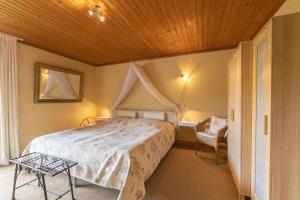 1 dormitorio con 1 cama con techo de madera en Ferienwohnung-Mediterran, en Einruhr