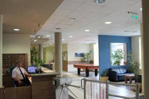 a man sitting at a desk in a hospital lobby at Famulus Kollégium in Győr