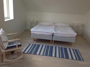 Habitación con 2 camas, silla y alfombra. en Ny Flintarp en Laholm