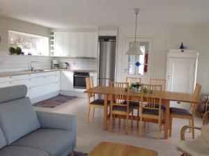 a kitchen and dining room with a table and chairs at Ny Flintarp in Laholm