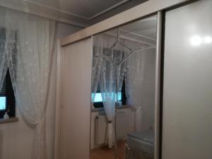 una camera con porta scorrevole in vetro con tende di Ferienwohnung Fischl a Rust