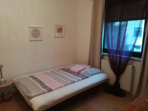 a small bed in a room with a window at Ferienwohnung Fischl in Rust