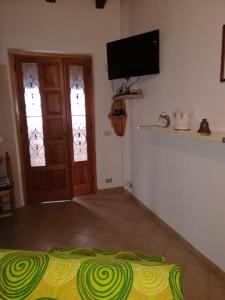 a room with a bed and a flat screen tv at Casa Lella in Domaso