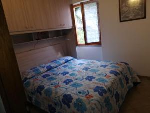 a bedroom with a bed with a colorful comforter at Casa Lella in Domaso