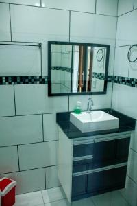 een badkamer met een wastafel en een spiegel bij Amsterdam lofts 2 in Poços de Caldas