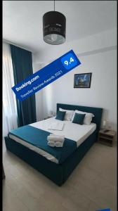 Schlafzimmer mit einem Bett mit blauem Schild darüber in der Unterkunft Roma Summerland in Mamaia