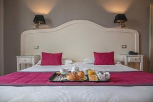 uma bandeja de comida sentada em cima de uma cama em Suite Castrense em Roma