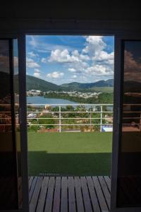 a door to a balcony with a view of a lake at Amsterdam lofts 2 in Poços de Caldas