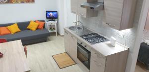 a kitchen with a stove and a couch in a room at QUIET HOUSE GARDEN NAPLES-POMPEI-SORRENTO in Trecase