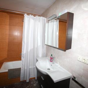 baño con lavabo y cortina de ducha en Pensión Como en Casa, en Rincón de Soto
