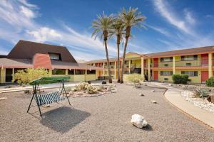 une aire de jeux en face d'un bâtiment avec des palmiers dans l'établissement Lake Place Inn Lake Havasu City, à Lake Havasu City