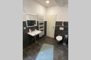 ein Bad mit einem Waschbecken und einem WC in der Unterkunft Schickes & gemütliches City Apartment 72qm 3Zimmer in Paderborn