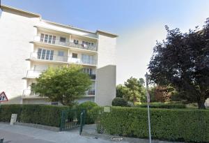 a large white building with bushes in front of it at Studio ScandiChic tout équipé centre-gare-rives-clinique à pied in Caen