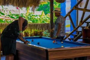 two men playing pool at a pool table at Primaluna Beach Hostel in Palomino