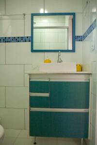uma casa de banho com um lavatório e um espelho em Amsterdam lofts 1 em Poços de Caldas