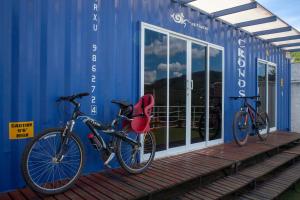 dos bicicletas estacionadas al lado de un edificio azul en Amsterdam lofts 1 en Poços de Caldas