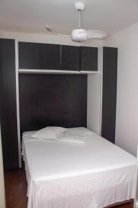 a bedroom with a white bed with a black headboard at Amsterdam lofts 4 in Poços de Caldas