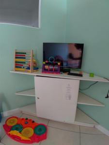 a shelf with a tv on top of it at Rio Búzios Beach Hotel in Búzios