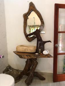 a mirror on top of a wooden stand in a bathroom at Eco Hostal Kuima in El Zaino