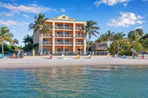 un hotel en la playa con palmeras y agua en Hutchinson Island Hotel, en Fort Pierce