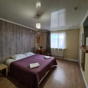 スラヴャンスク・ナ・クバニにあるMini-Hotel Svetlanaのベッドルーム1室(ベッド1台、タオル2枚付)