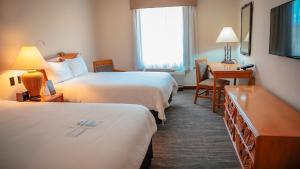 a hotel room with two beds and a desk at Quality Hotel Real Aeropuerto Santo Domingo in Boca Chica