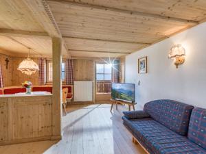 a living room with a blue couch and a table at Biobauernhof Fleckl in Hopfgarten im Brixental