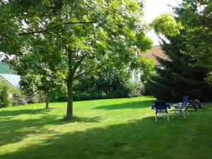 einen Park mit Stühlen und einem Tisch im Gras in der Unterkunft Hotelpension Gästehaus Birgit in Bad Mergentheim