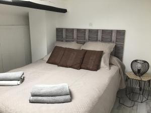 1 dormitorio con 1 cama blanca grande y 2 almohadas en Face à la mer en Saint-Aygulf