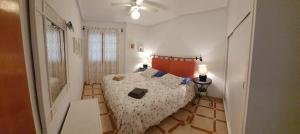 a small bedroom with a bed and two lamps at MEDITERRANEAN BEACH APARTMENT 180º SEA & ISLAND VIEWS in Santa Pola