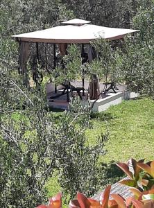 cenador con mesa y sillas en el jardín en Traditional Villa Fioretta, en Mármaron