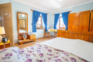 1 dormitorio con 1 cama grande con cortinas azules en Notranjska hiša - traditional country house, close to the world attraction Cerknica lake en Begunje pri Cerknici