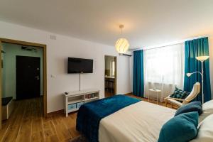a bedroom with a bed and a flat screen tv at Brand relaxing place close to Iulius Mall in Timişoara
