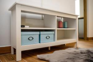a white shelf with two blue boxes in a room at Brand relaxing place close to Iulius Mall in Timişoara