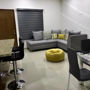 sala de estar con sofá, mesa y sillas en Departamento nuevo a 3 min de la playa en Mazatlán