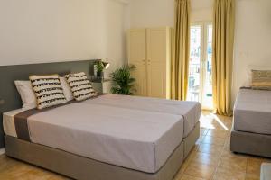 a bedroom with a bed with two pillows on it at La FLEUR apartments in Skiathos