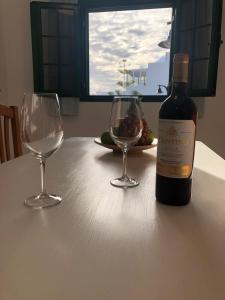 una botella de vino y dos copas de vino en una mesa en Villas Yaiza. El Golfo, en El Golfo